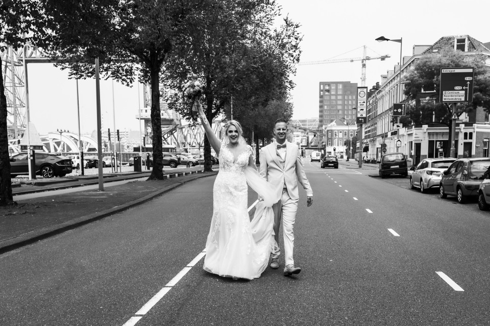 een bruid en bruidegom lopen over straat