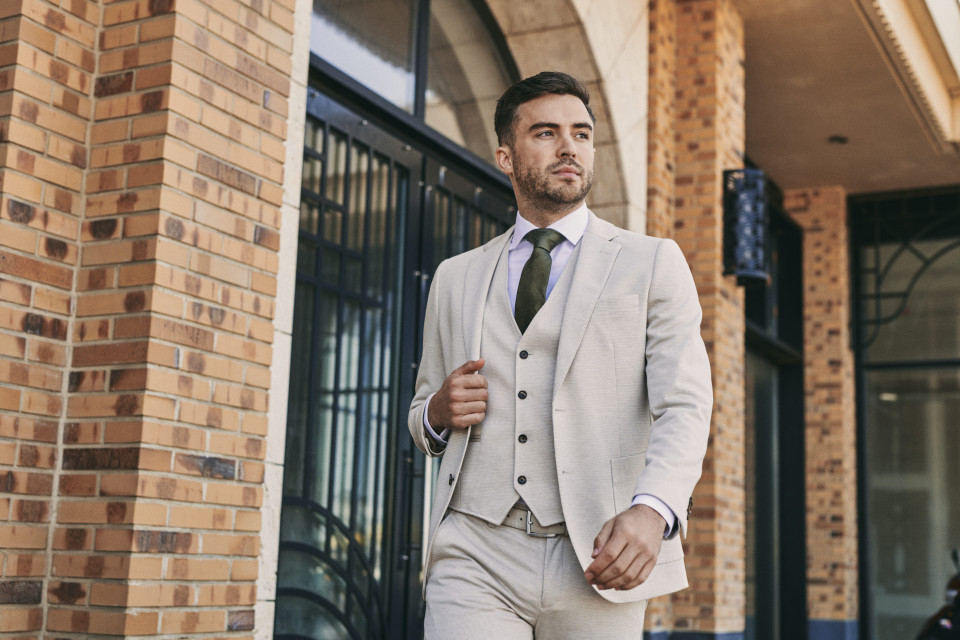 een man in een pak die de straat afloopt