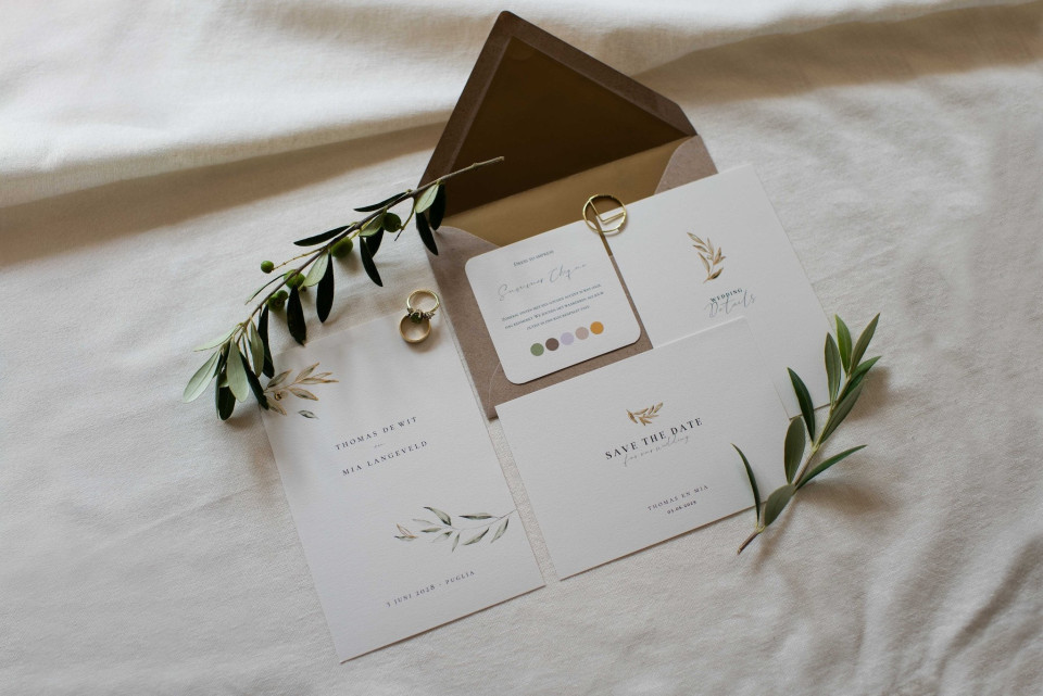 een foto van een trouwuitnodiging met een ring erop
