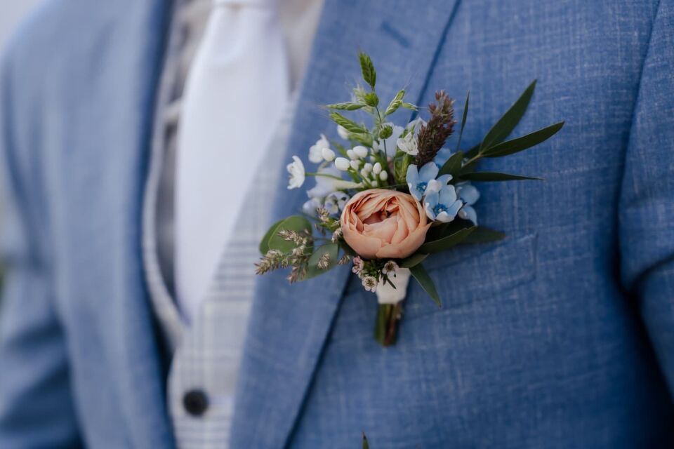 een man in een blauw pak met een bloem op zijn revers