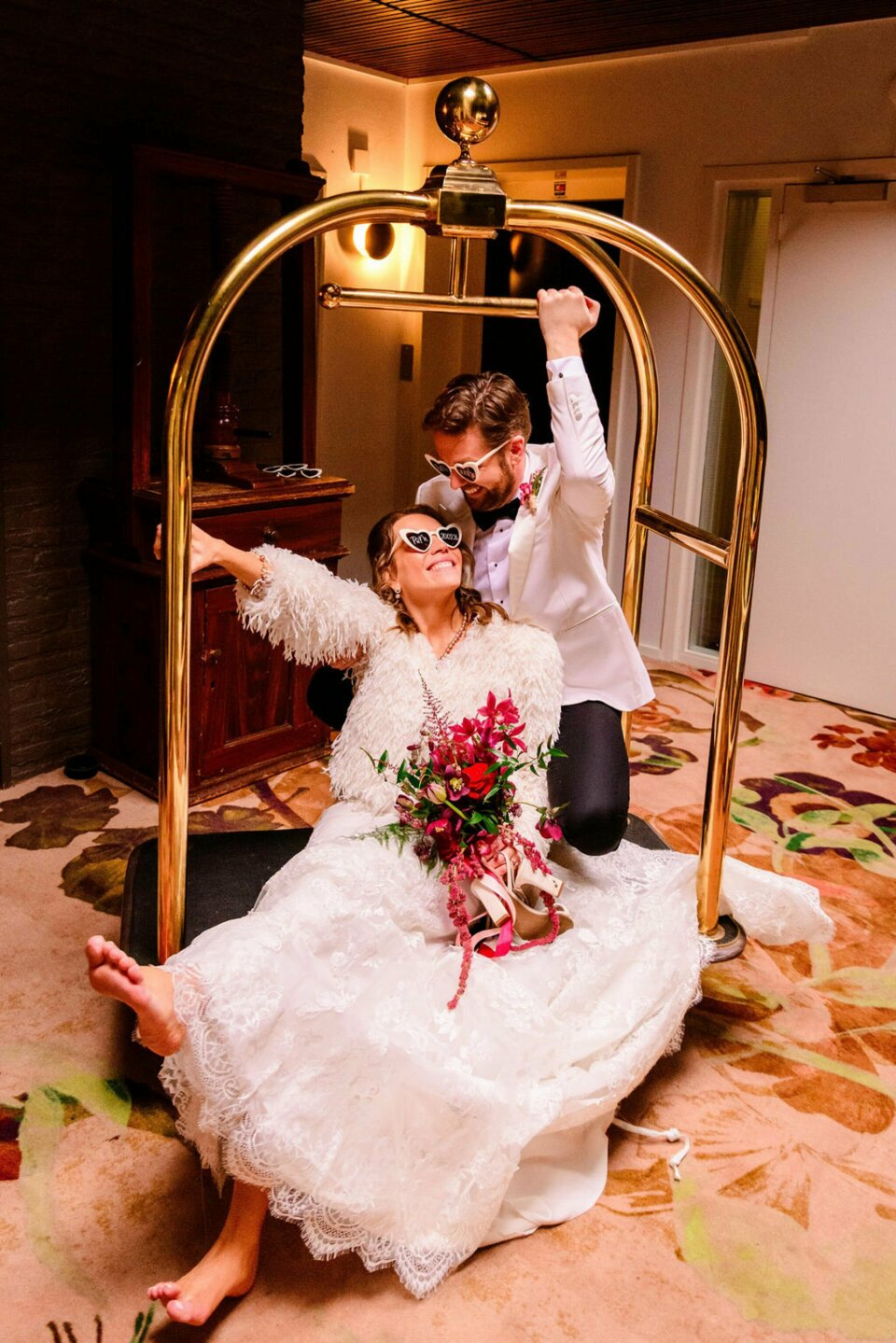 een man en een vrouw zitten op een bed in een hotelkamer