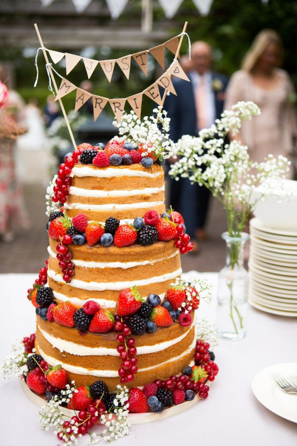 een bruidstaart met bessen en vlaggetjes