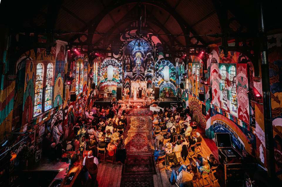 een luchtfoto van een kerk met mensen die in de banken zitten