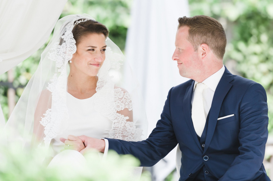 een bruid en bruidegom zitten samen onder een paraplu