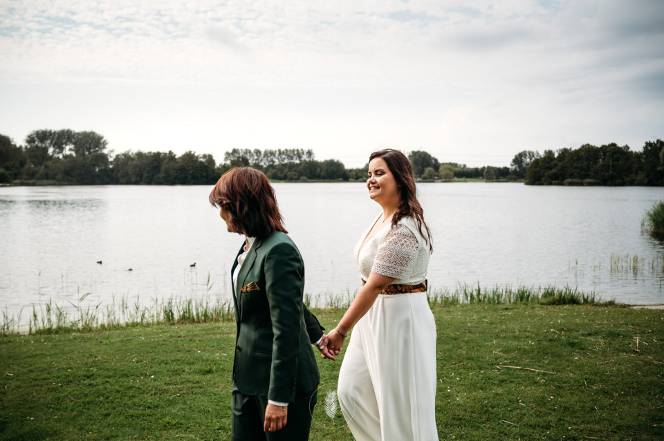 een man en een vrouw die hand in hand staan voor een waterlichaam