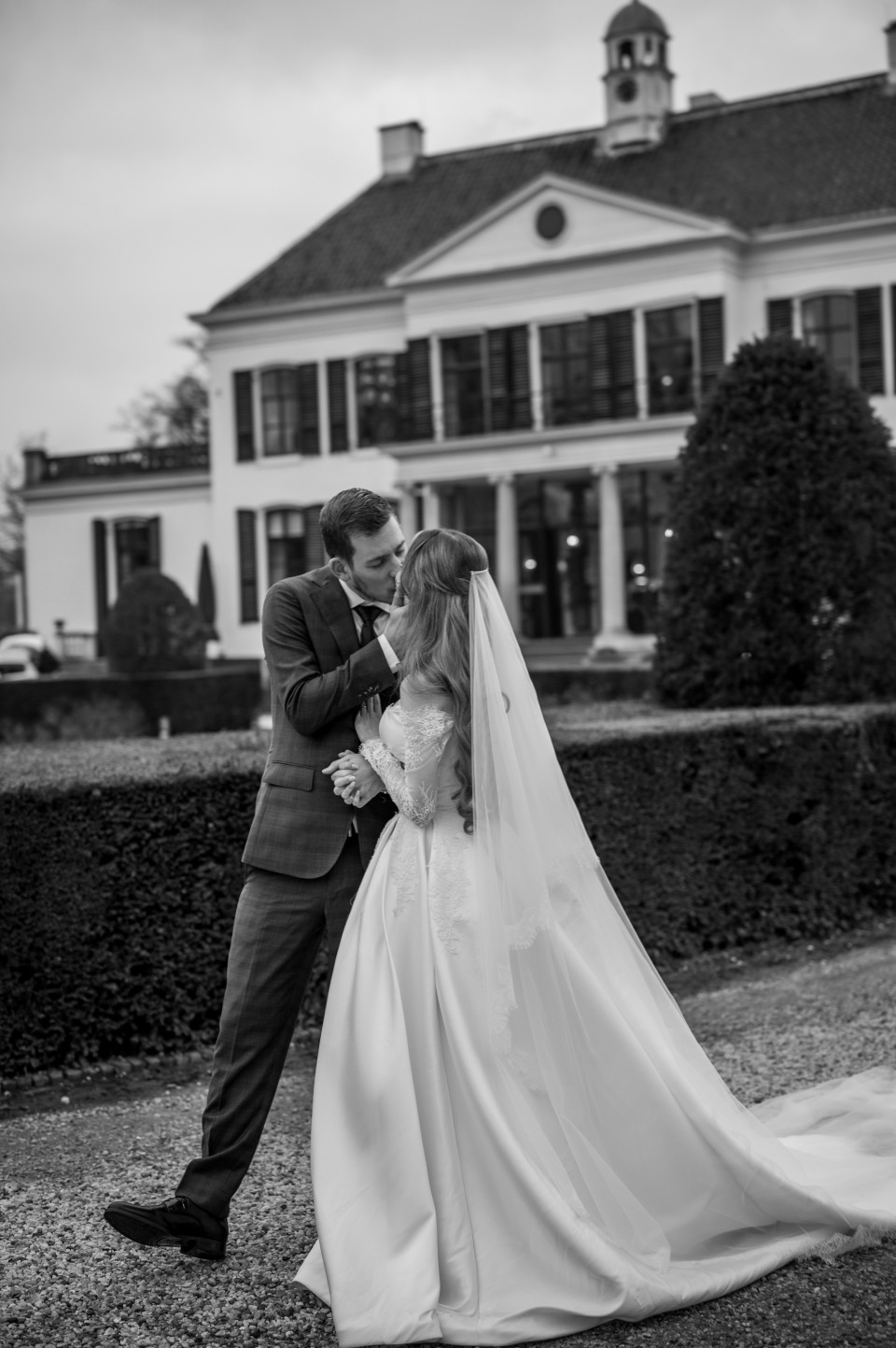de bruid en bruidegom die kussen voor het landhuis