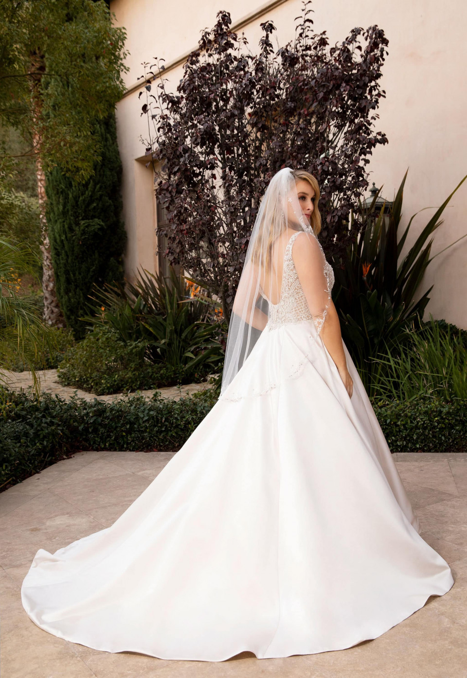 een bruid in een trouwjurk staat voor een huis