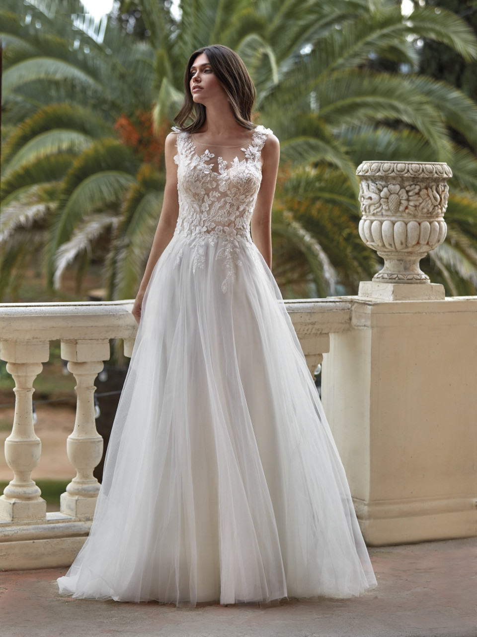 een vrouw in een trouwjurk staat op een balkon