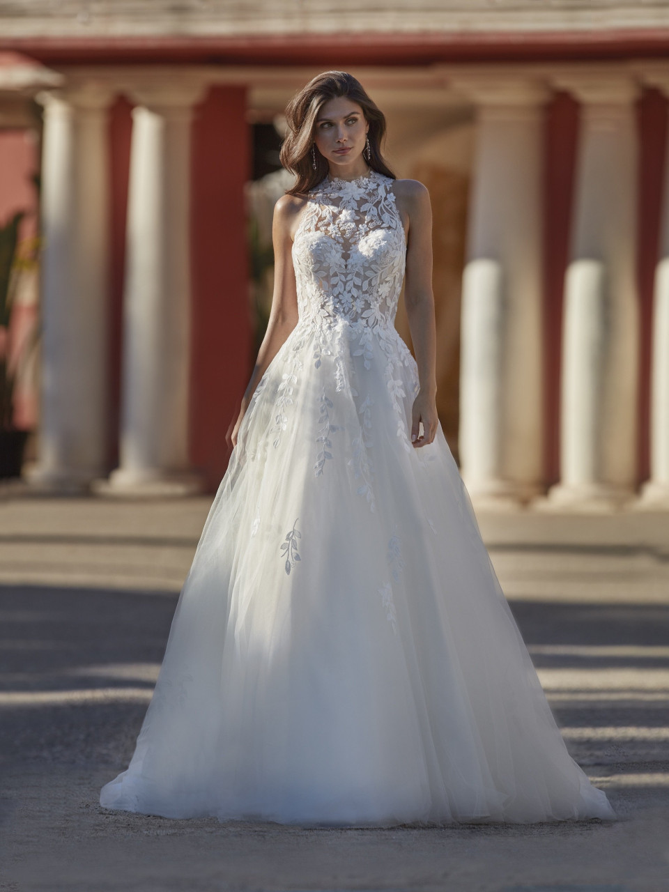 een vrouw in een trouwjurk die voor een gebouw staat