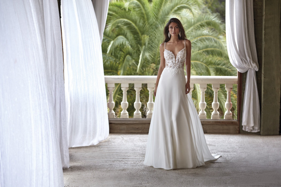 een vrouw in een trouwjurk die op een balkon staat