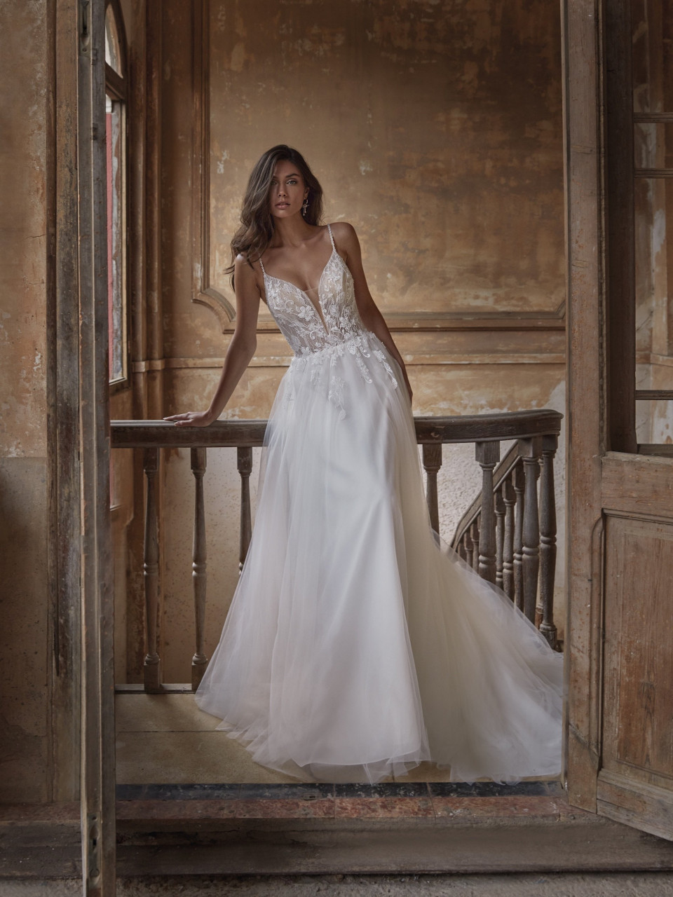 een vrouw in een trouwjurk die op een balkon staat