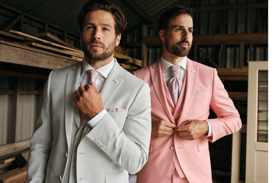 twee mannen in roze pakken staan naast elkaar