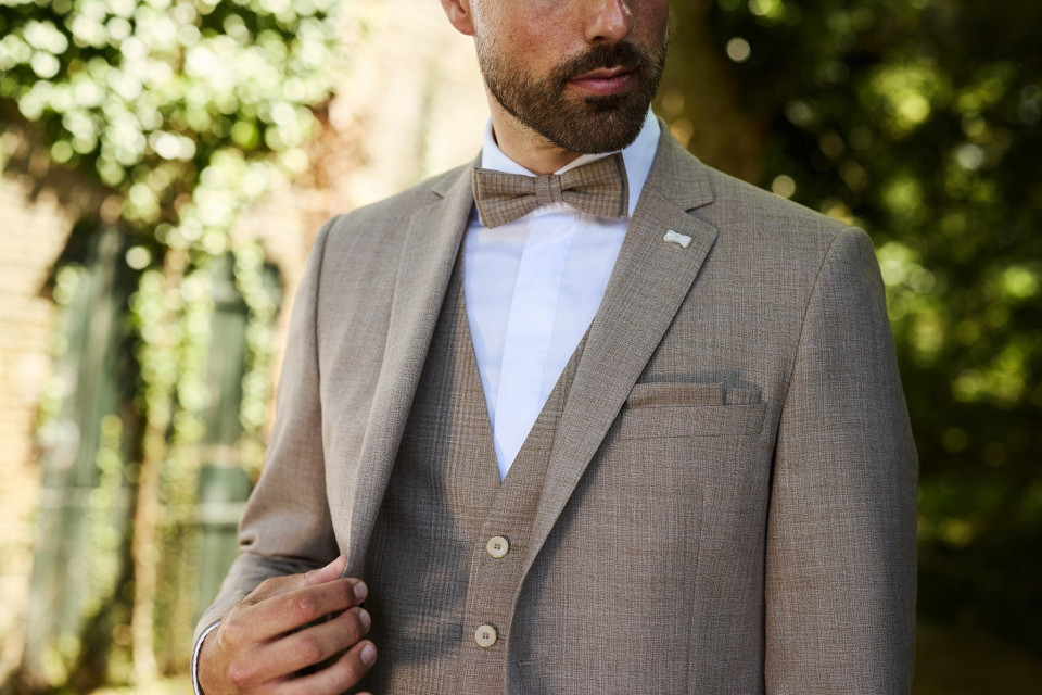 een close-up van een man in een pak en strikje