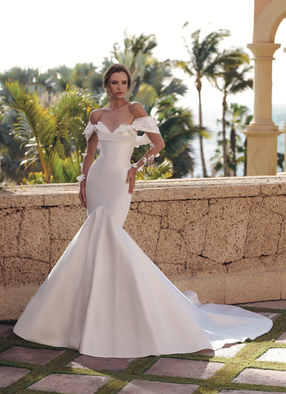 de trouwjurk is ontworpen met off-shoulder mouwen en een lange sleep