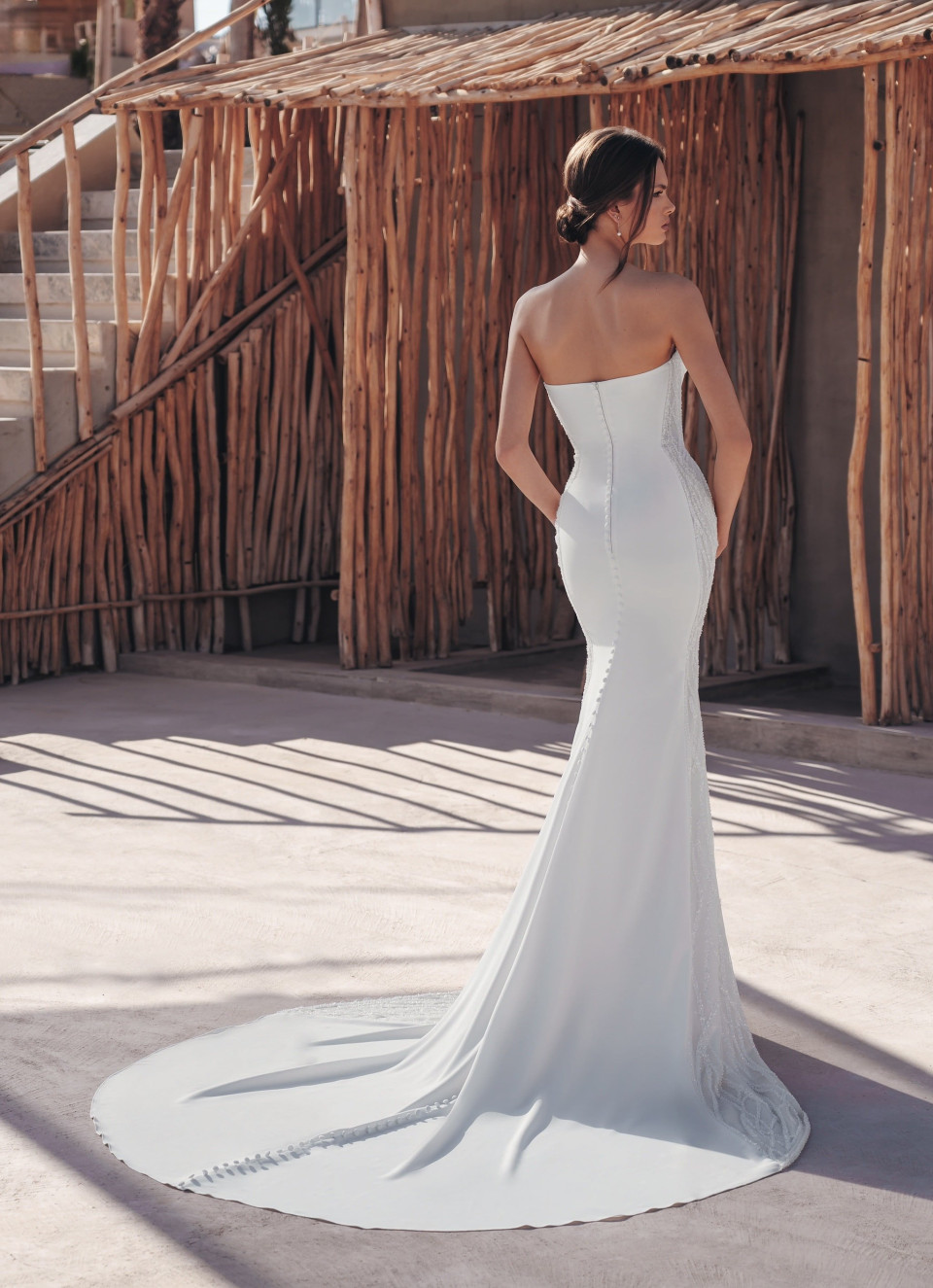 de achterkant van een vrouw die een strapless trouwjurk draagt