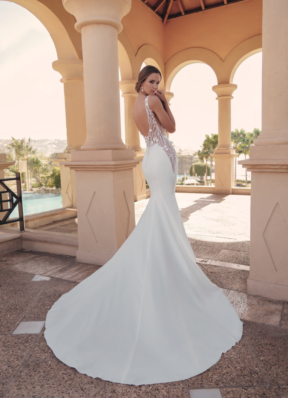 de achterkant van een trouwjurk met een wit kanten lijfje en een sleep