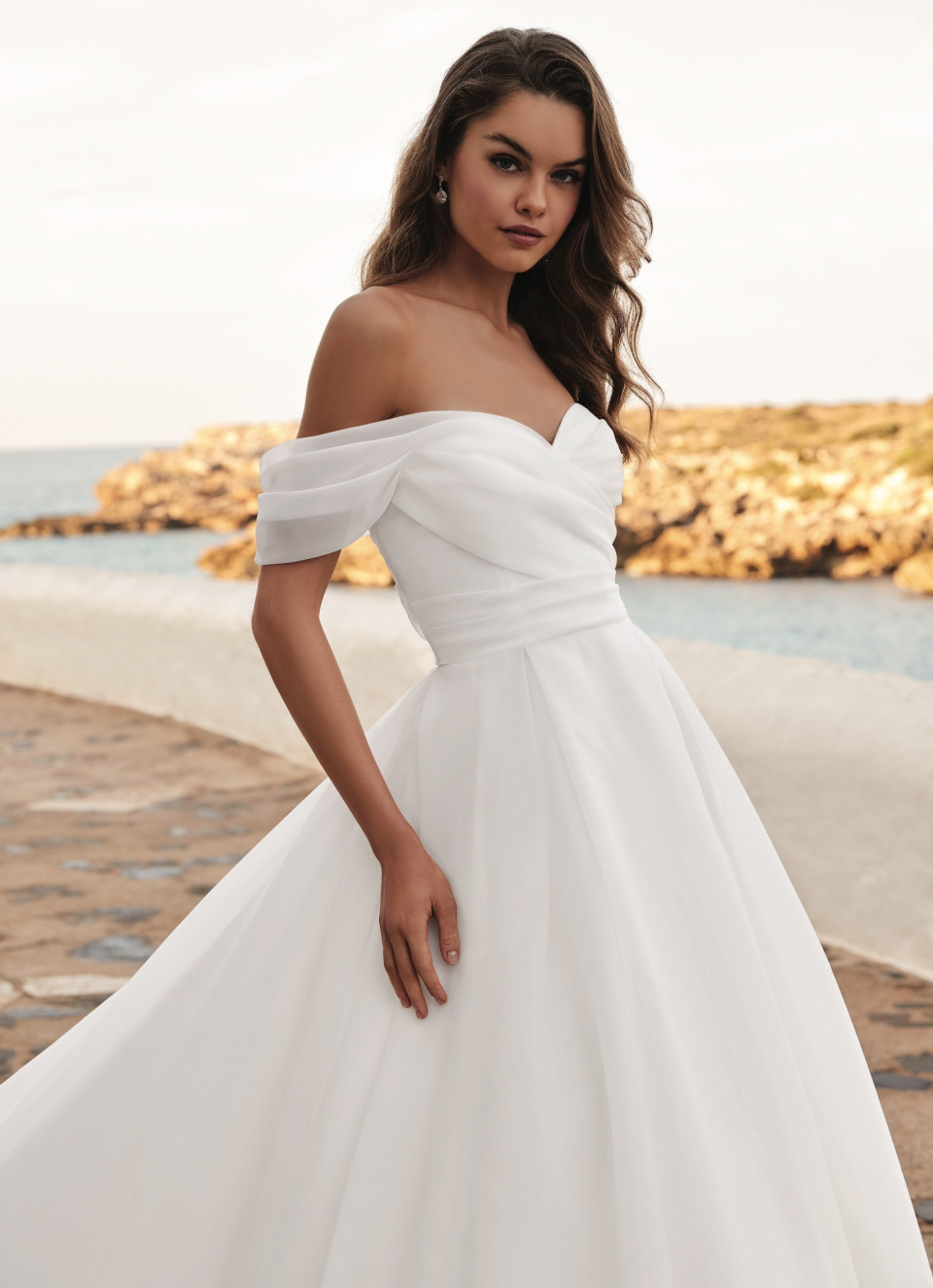 de trouwjurk is wit met off-shoulder bandjes