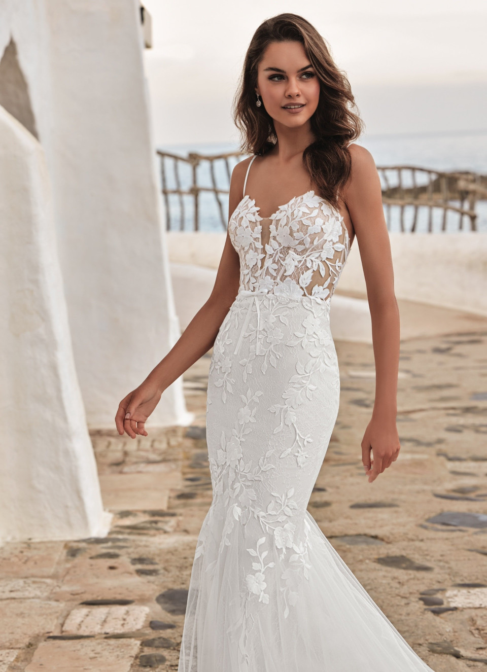 de trouwjurk is gemaakt van kant en heeft een diepe v-halslijn