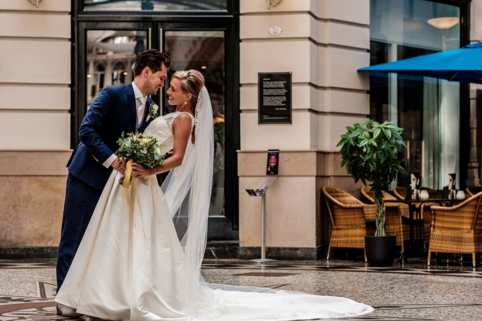 een bruid en bruidegom kussen voor een gebouw