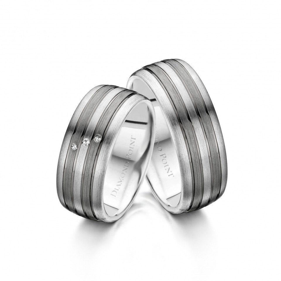 twee trouwringen met een witgouden band en een zwarte streep