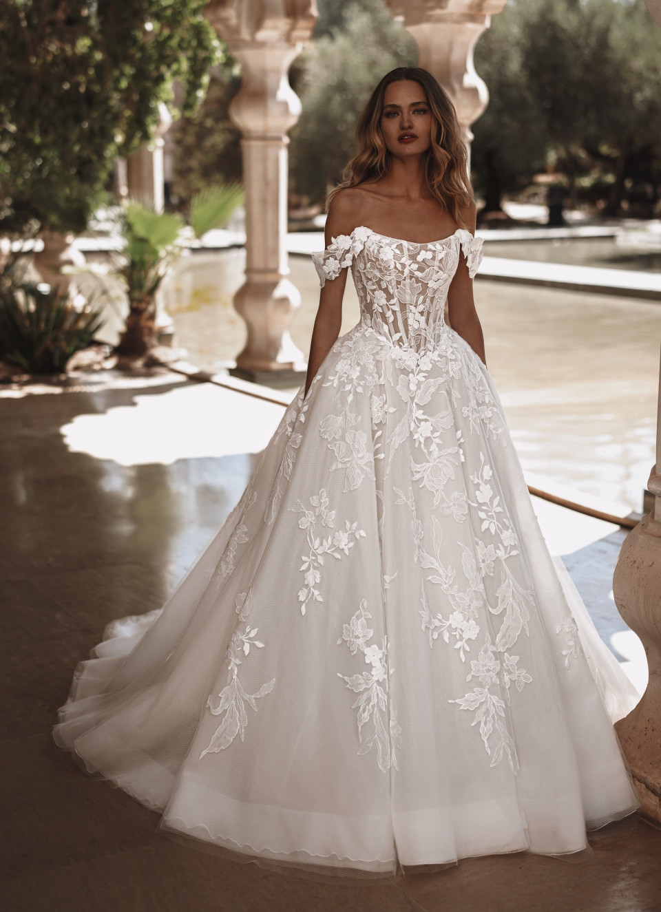 een vrouw in een trouwkleed poseert voor een foto