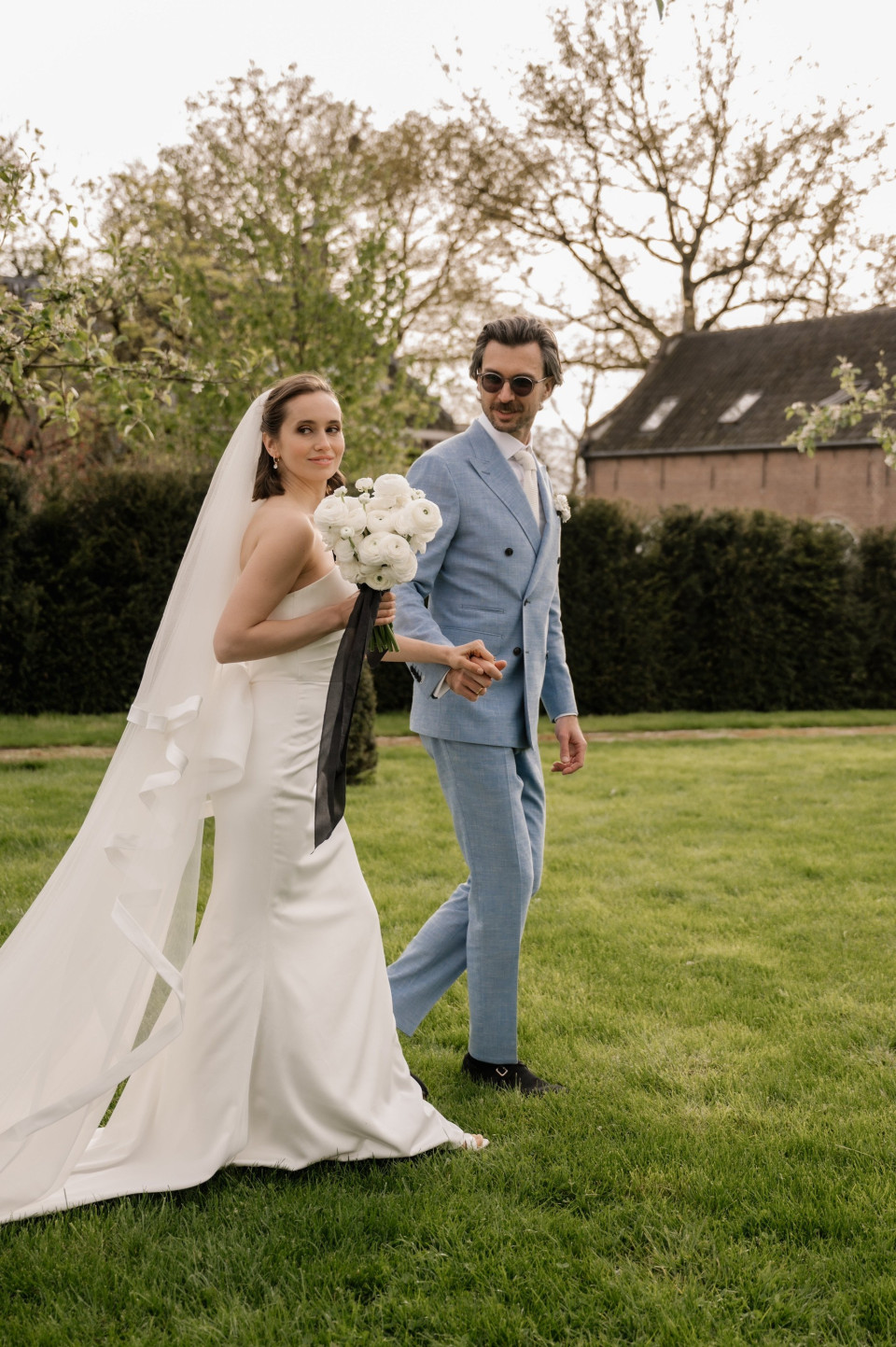 een bruid en bruidegom lopen in het gras