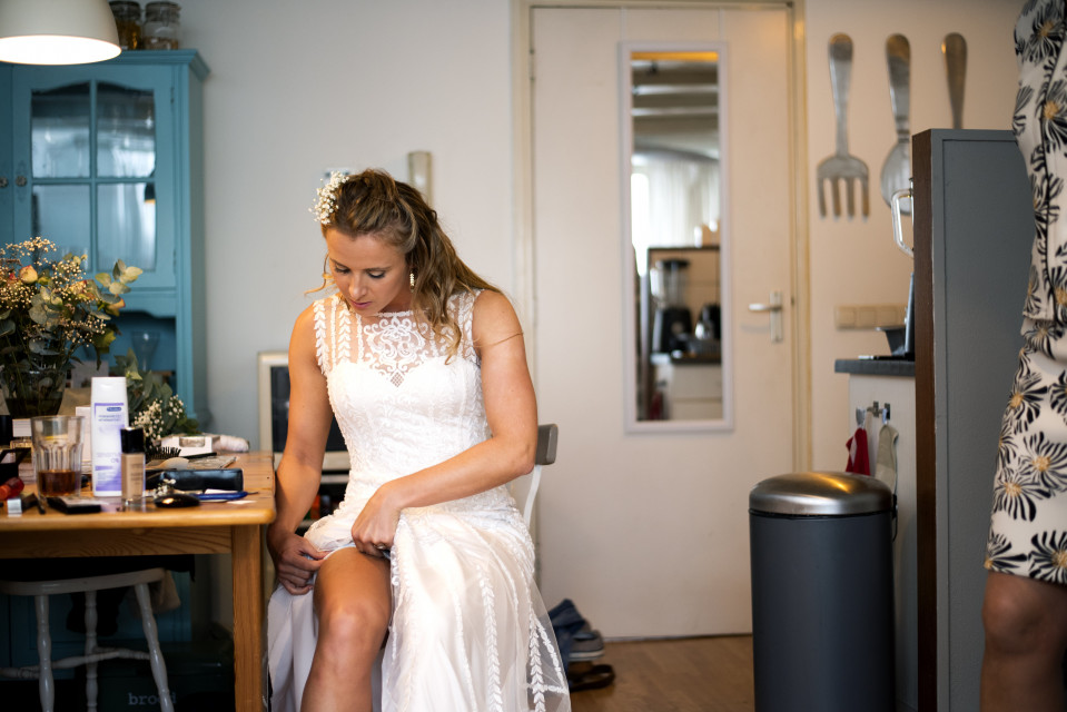 een vrouw in een trouwjurk die aan een tafel zit