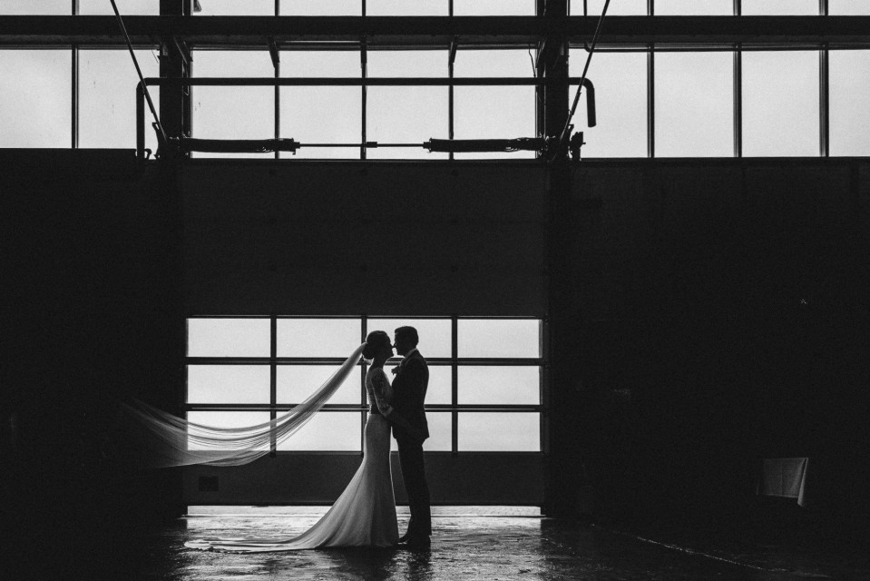 een bruid en bruidegom poseren voor een groot raam