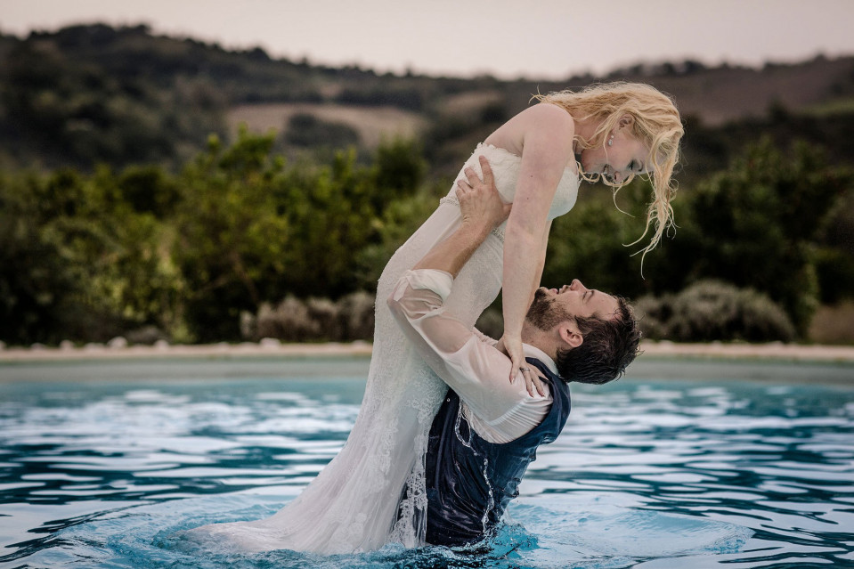 een bruid en bruidegom in een zwembad die elkaar vasthouden