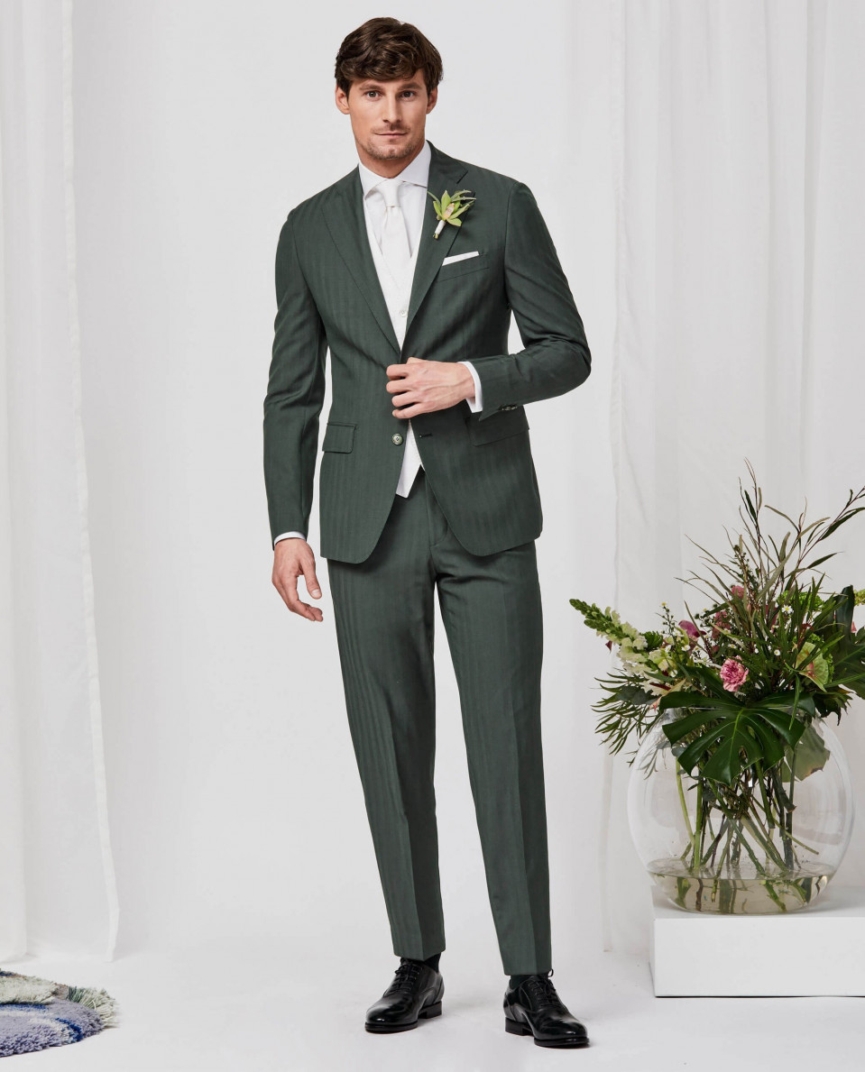 een man in een groen pak en wit overhemd