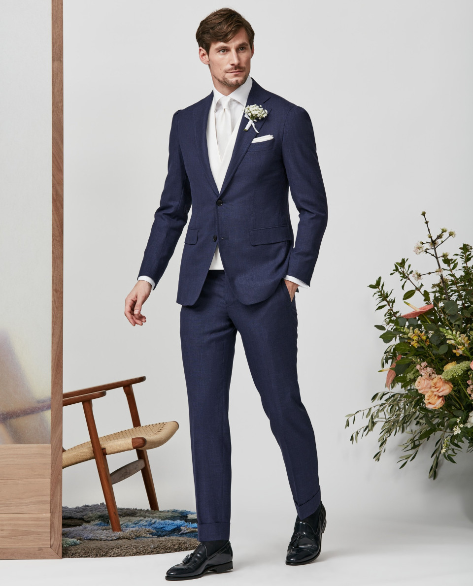 een man in een blauw pak en wit overhemd