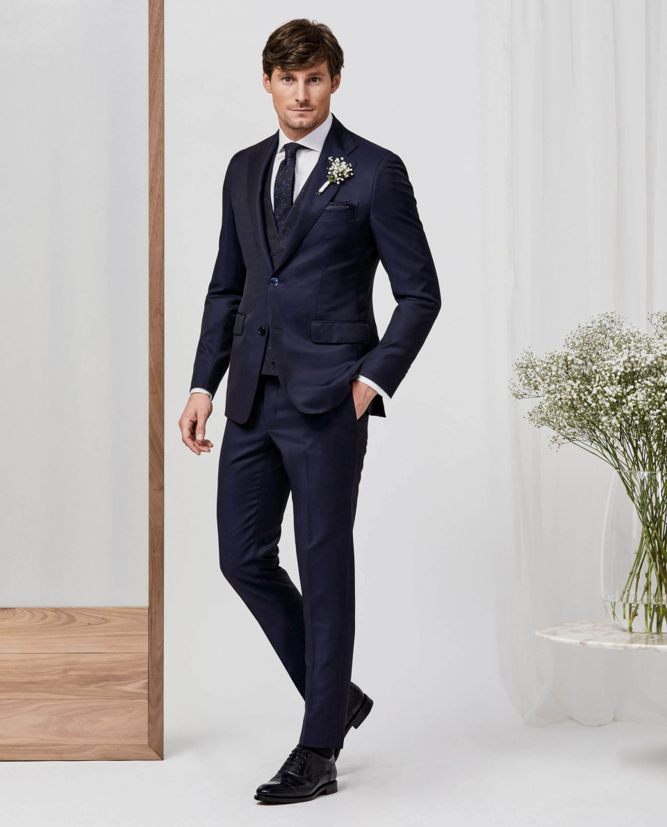 een man in een blauw pak en zwarte schoenen