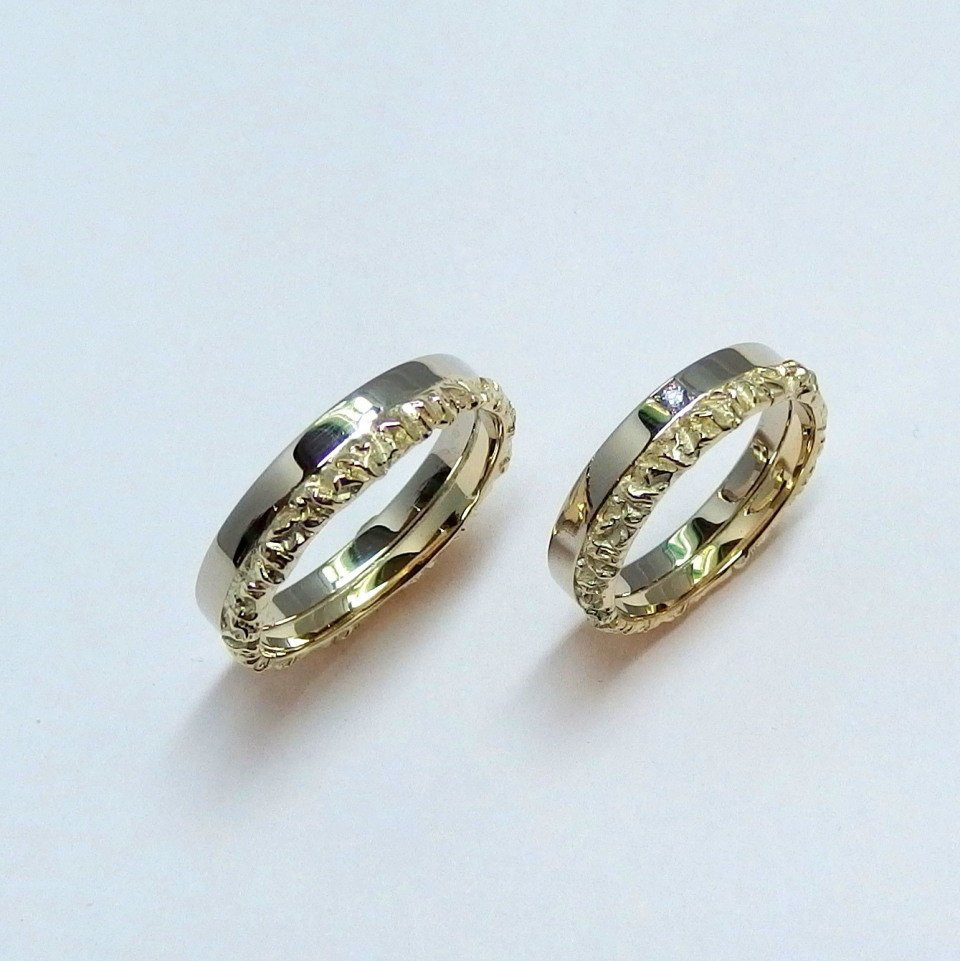 twee trouwringen met gouden en zilveren banden