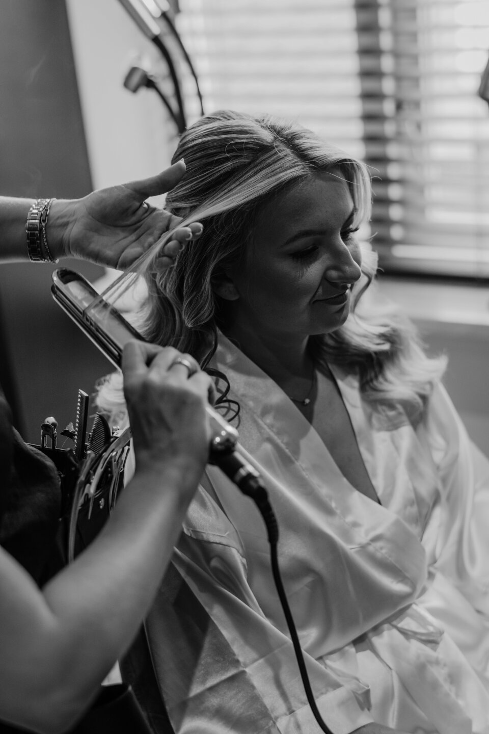 een zwart-witfoto van een vrouw die haar haar laat doen