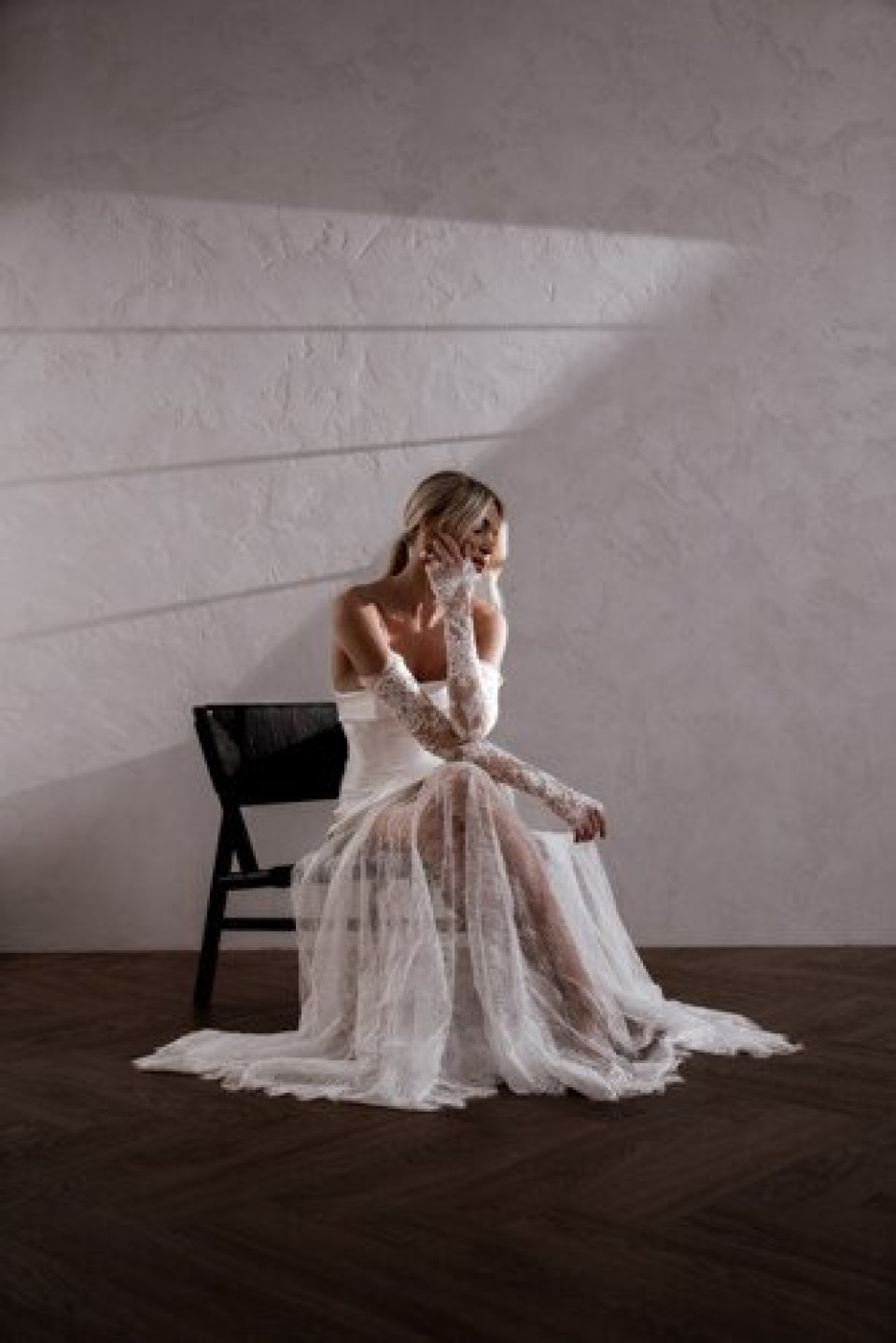 een vrouw die op een stoel zit in een witte jurk