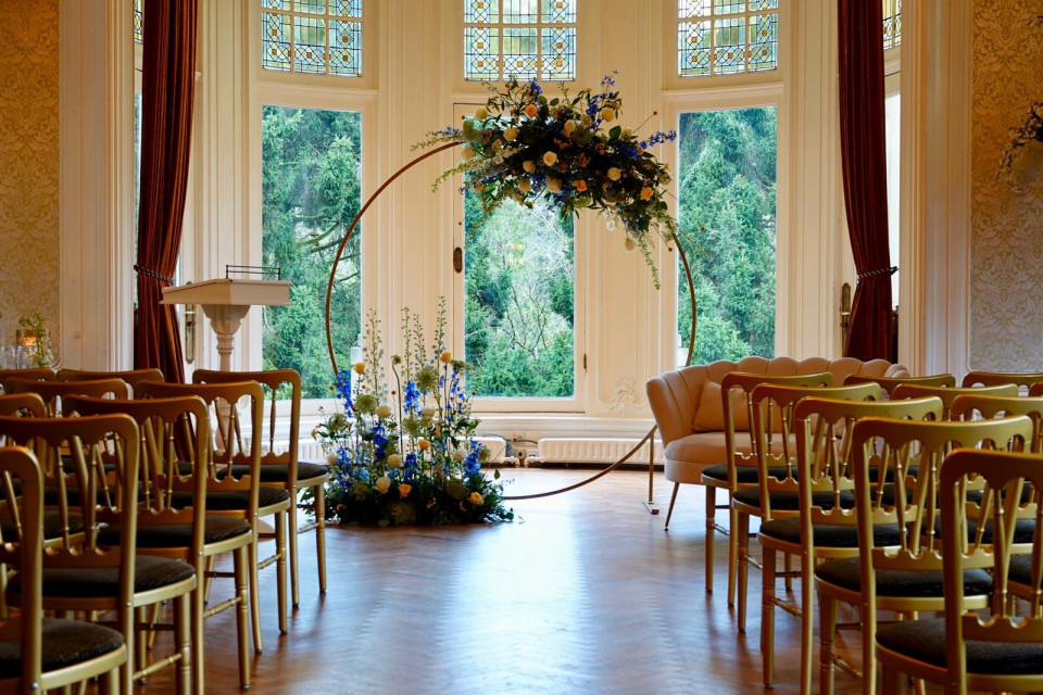 een bruiloftsceremonie in een grote zaal met stoelen