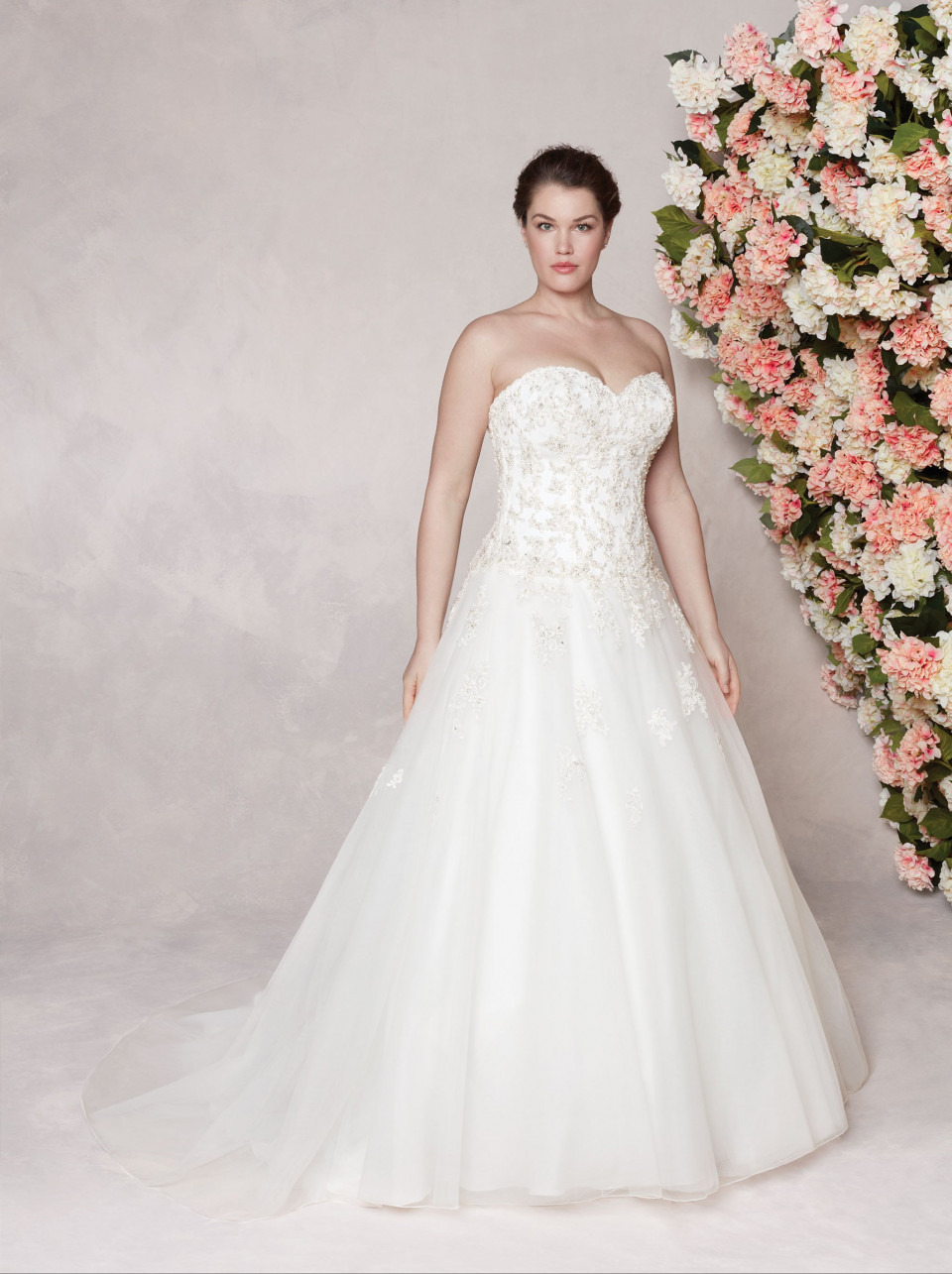 een plus-size trouwjurk met een strapless lijfje en een parelmoer rok