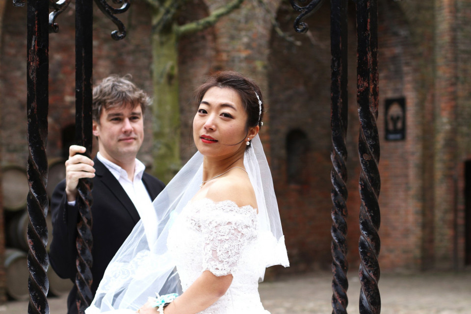 een bruid en bruidegom poseren voor een foto voor een poort