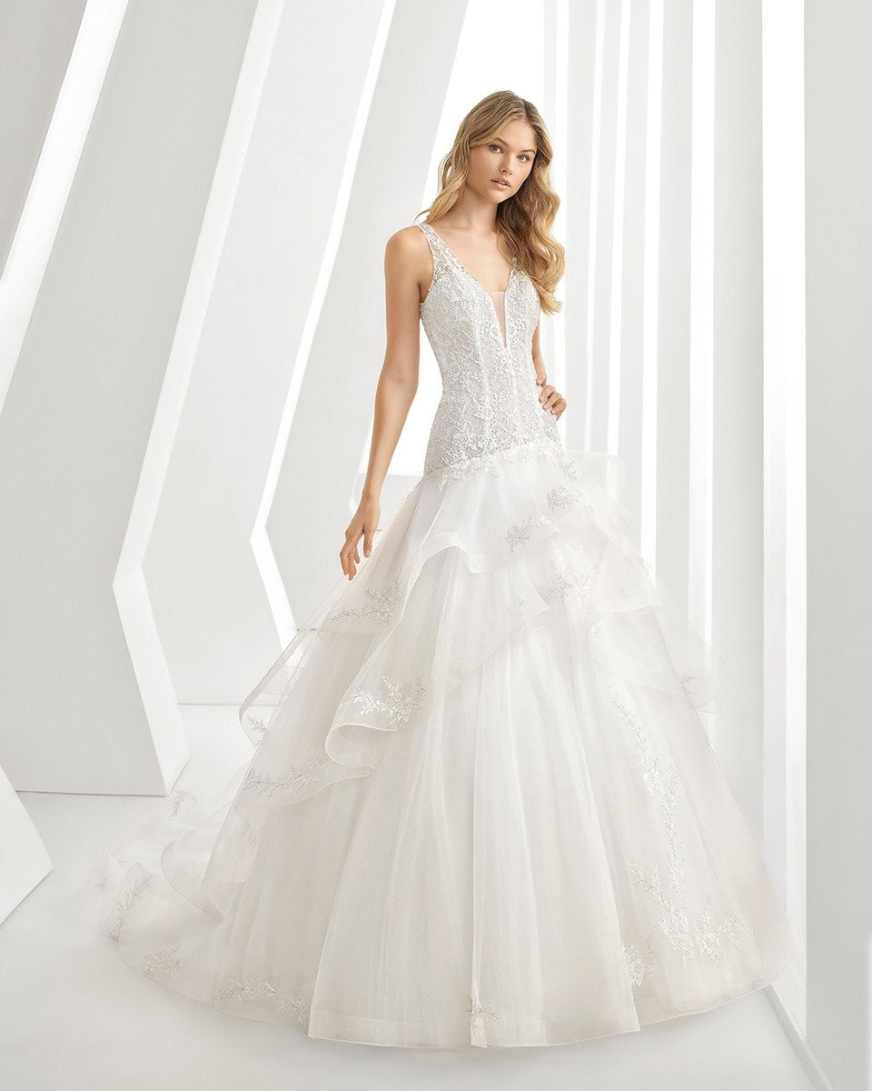 de trouwjurk is een prachtige witte japon met een v-hals en gerimpelde rok