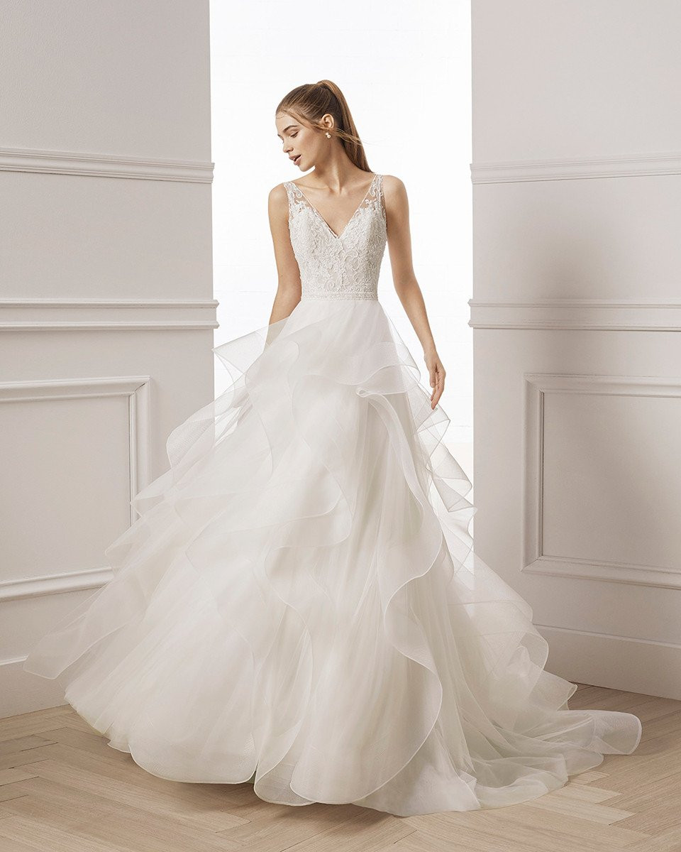 de trouwjurk is wit en heeft een gerimpelde rok