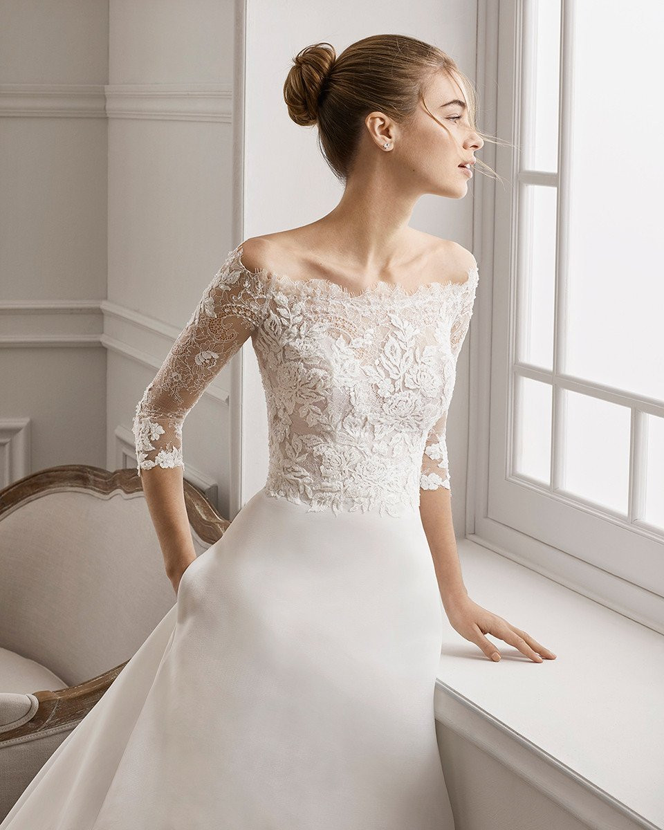 de trouwjurk is een prachtige witte jurk met kant en off-shoulder mouwen