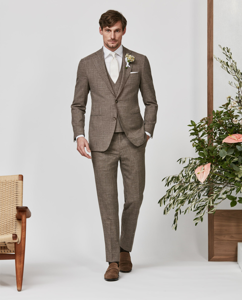 een man in een pak en stropdas loopt door een witte gang