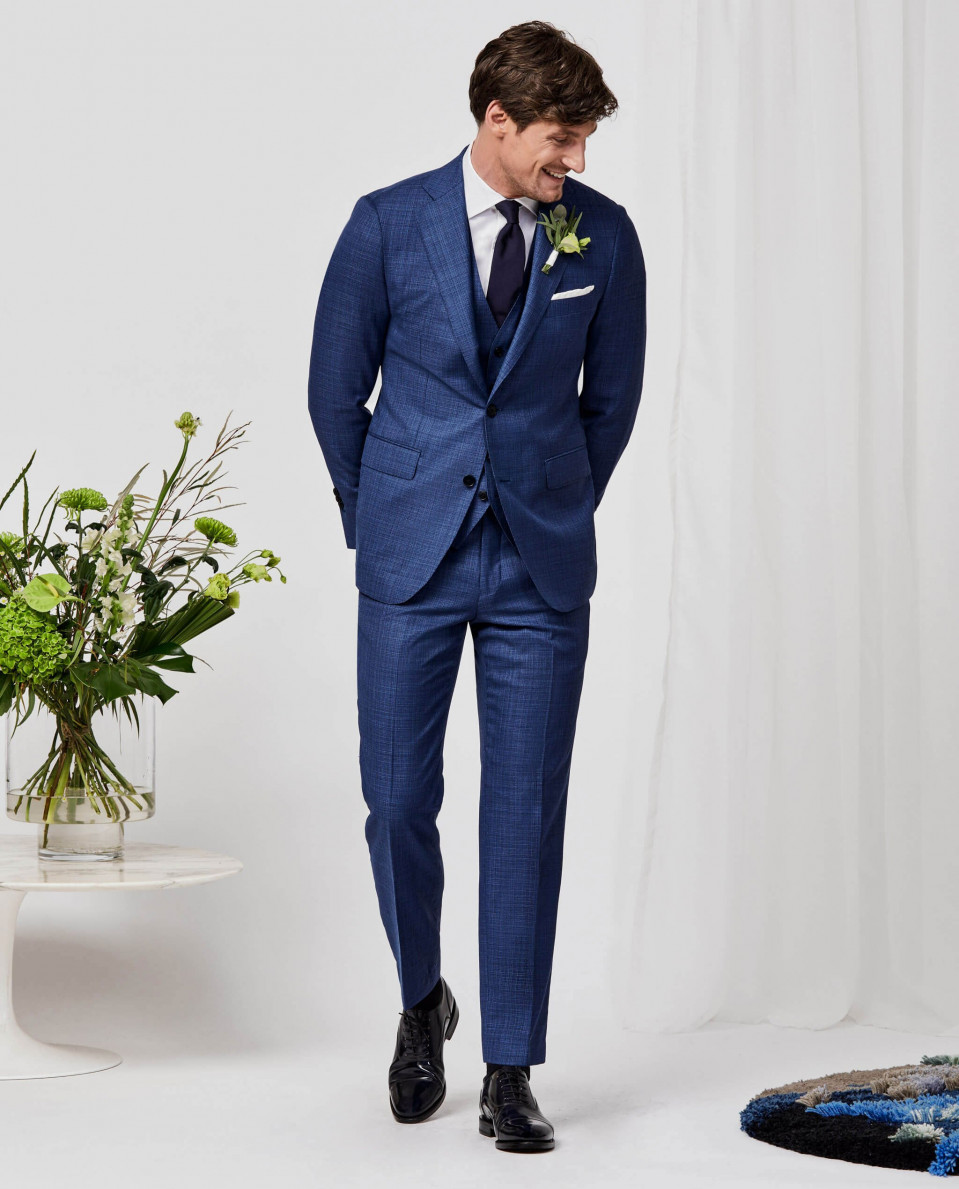 een man in een blauw pak en zwarte schoenen