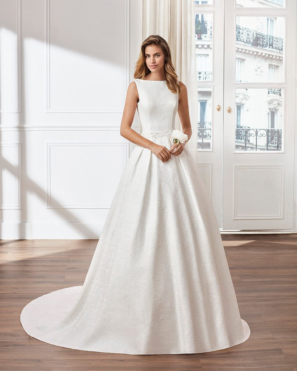 de trouwjurk is gemaakt van satijn en heeft een lage halslijn