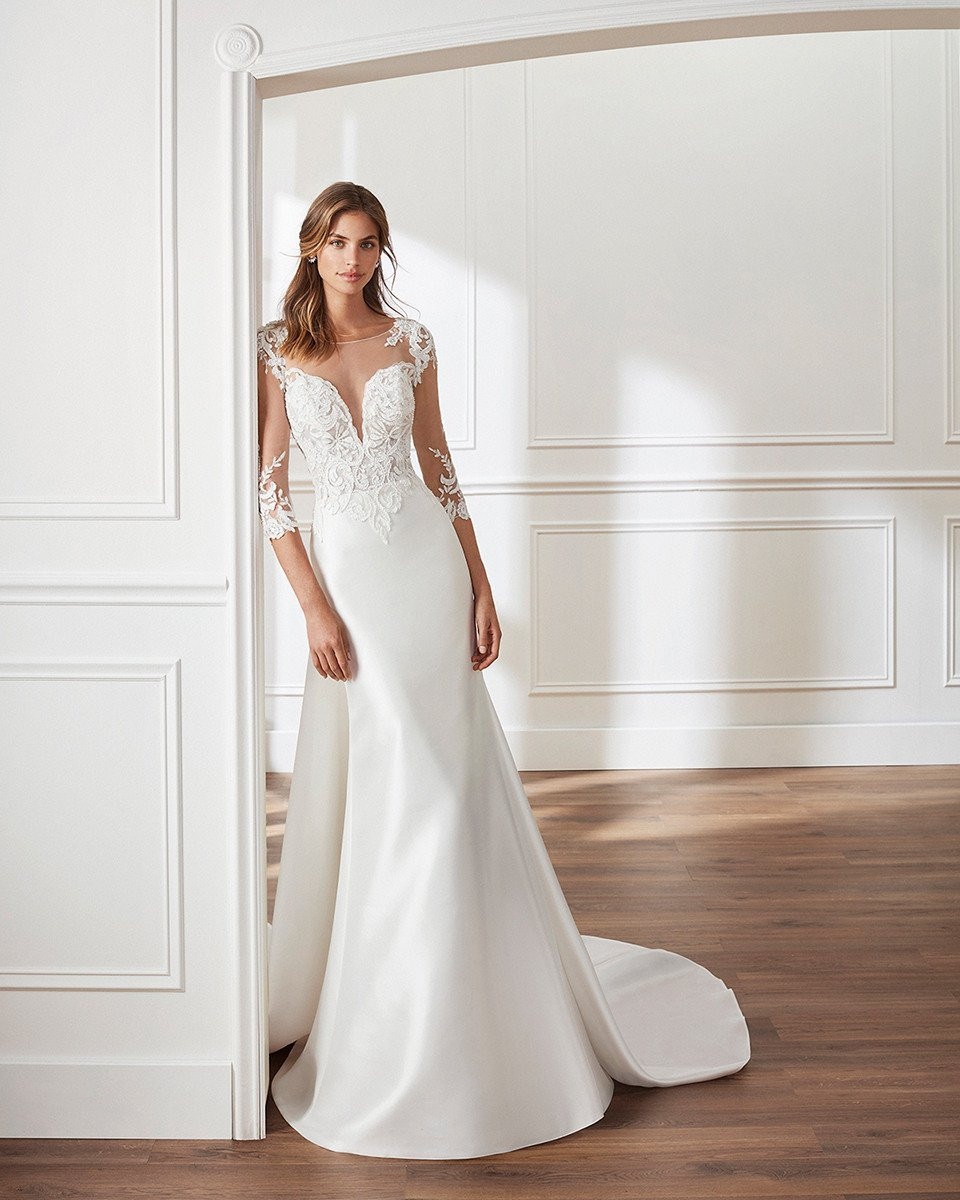 de trouwjurk is een prachtige lange mouw japon met doorschijnende mouwen en een