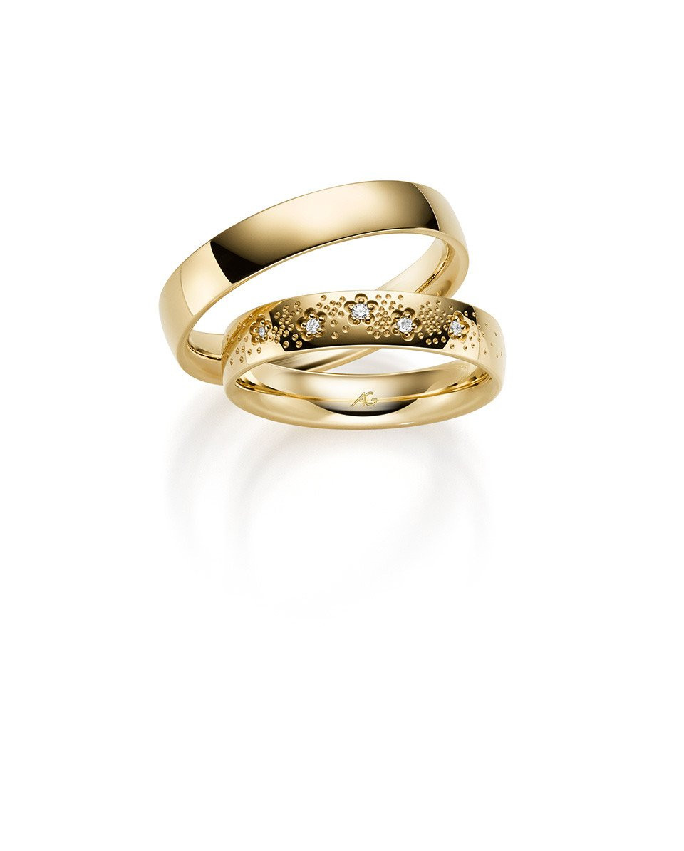 twee trouwringen in geelgoud met diamanten