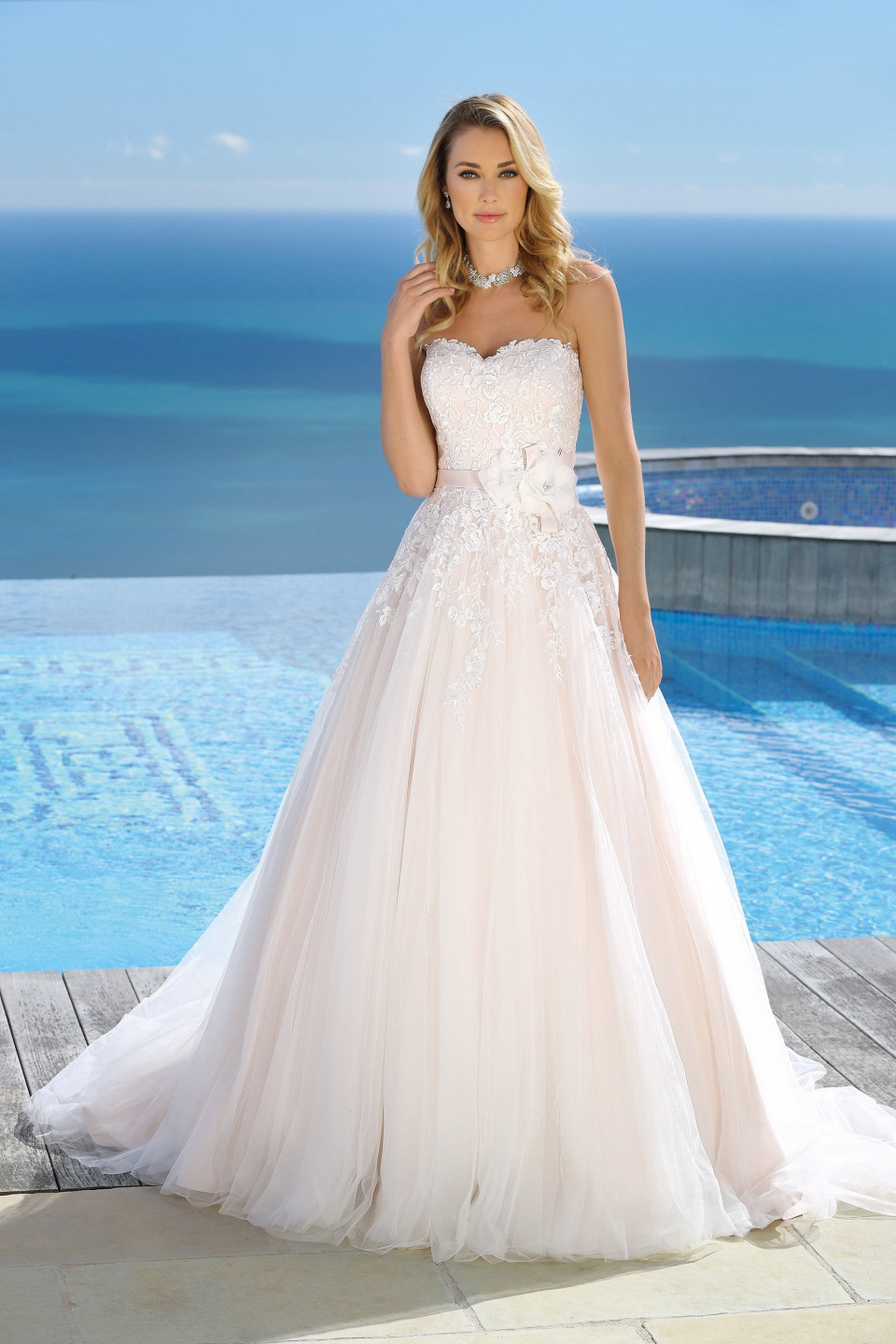 een mooie vrouw in een trouwjurk bij het zwembad