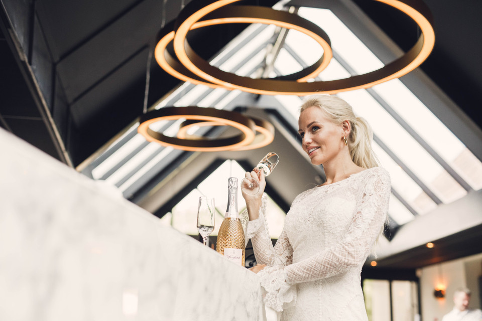een bruid die een glas wijn vasthoudt op een trouwreceptie