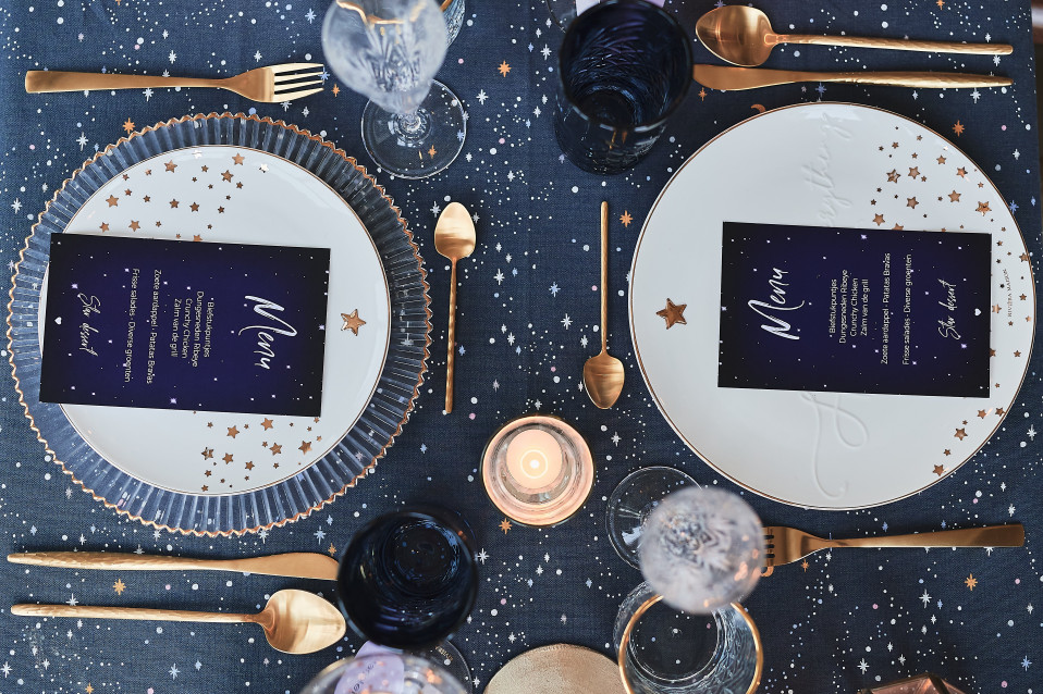 een tafel gedekt met gouden en blauwe borden en tafelgerei
