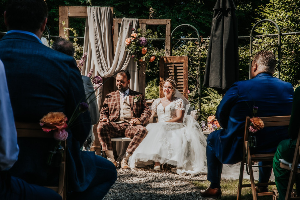 een man en een vrouw die zitten bij een huwelijksceremonie